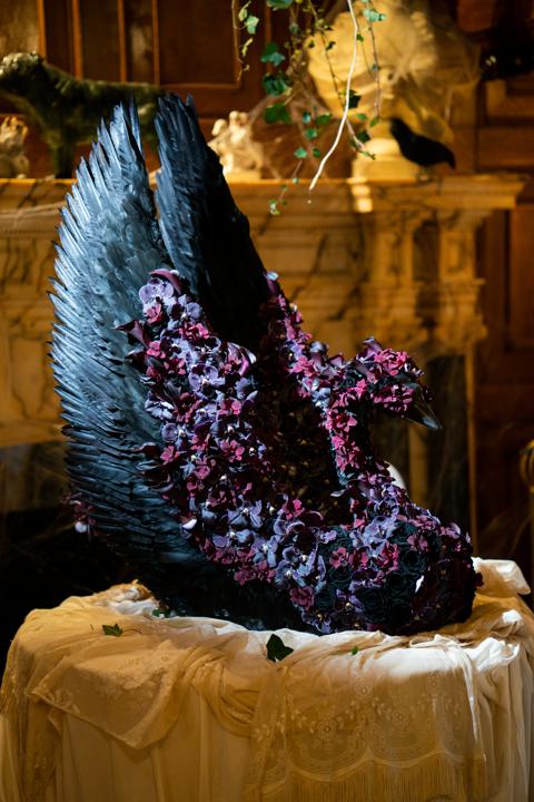 The Black Swan flower sculpture in black feathers and deep purple blooms