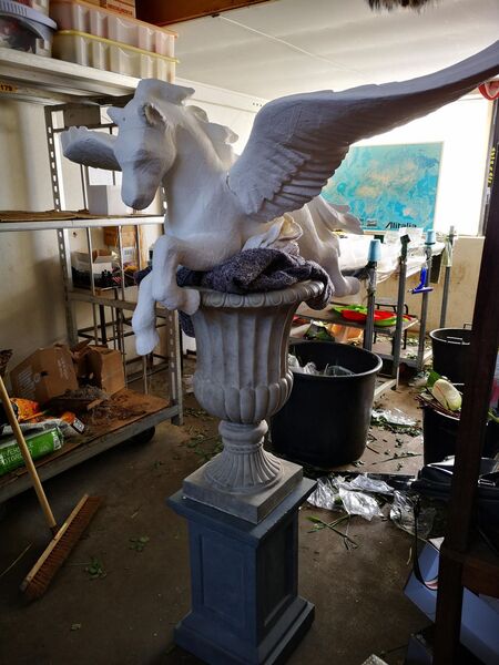 The bare carved Pegasus form on its urn and column in the atelier, before any flowers
